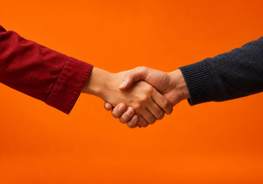 Twee mensen die elkaar de hand schudden in brancheverenigingen.