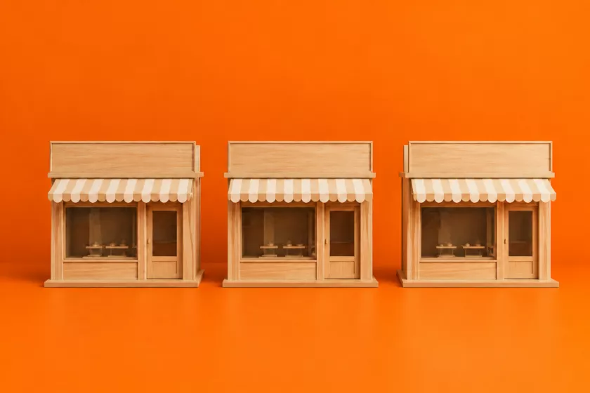 Drie houten winkelpuien als symbool voor de franchise.