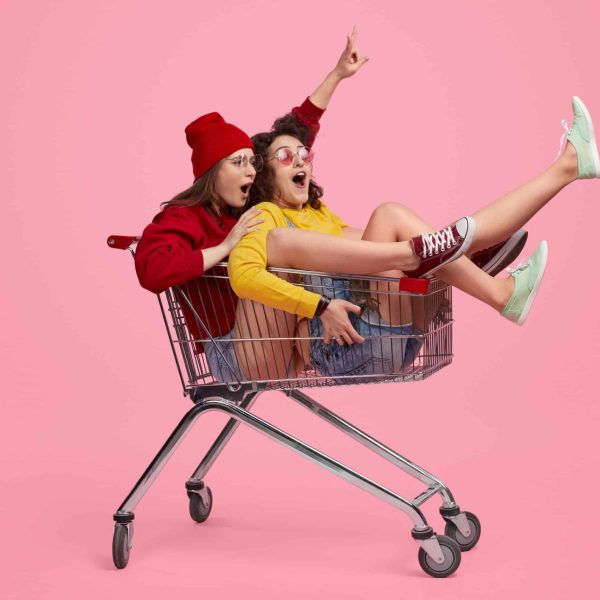 Side,View,Of,Two,Young,Women,Screaming,And,Riding,Shopping